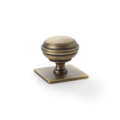 Quantock antique brass cabinet knob on square backplate - 34mm